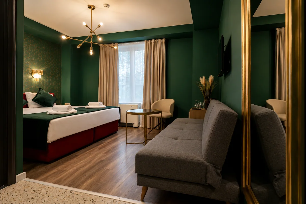 Grünes Dreibettzimmer mit Doppelbett und Sofa